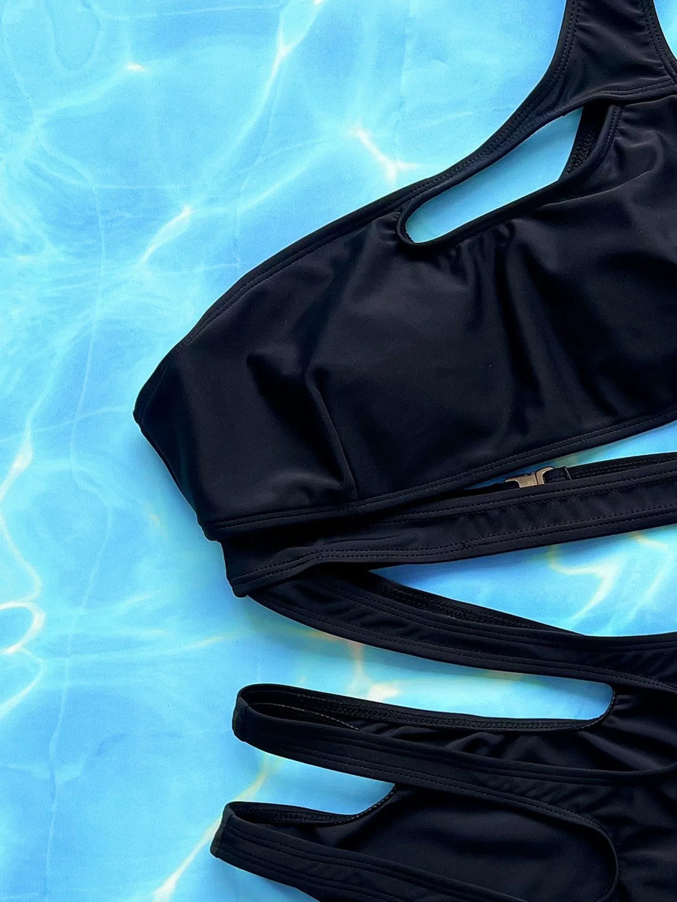 Black women's one-piece swimsuit with hollow out strap design showing size chart