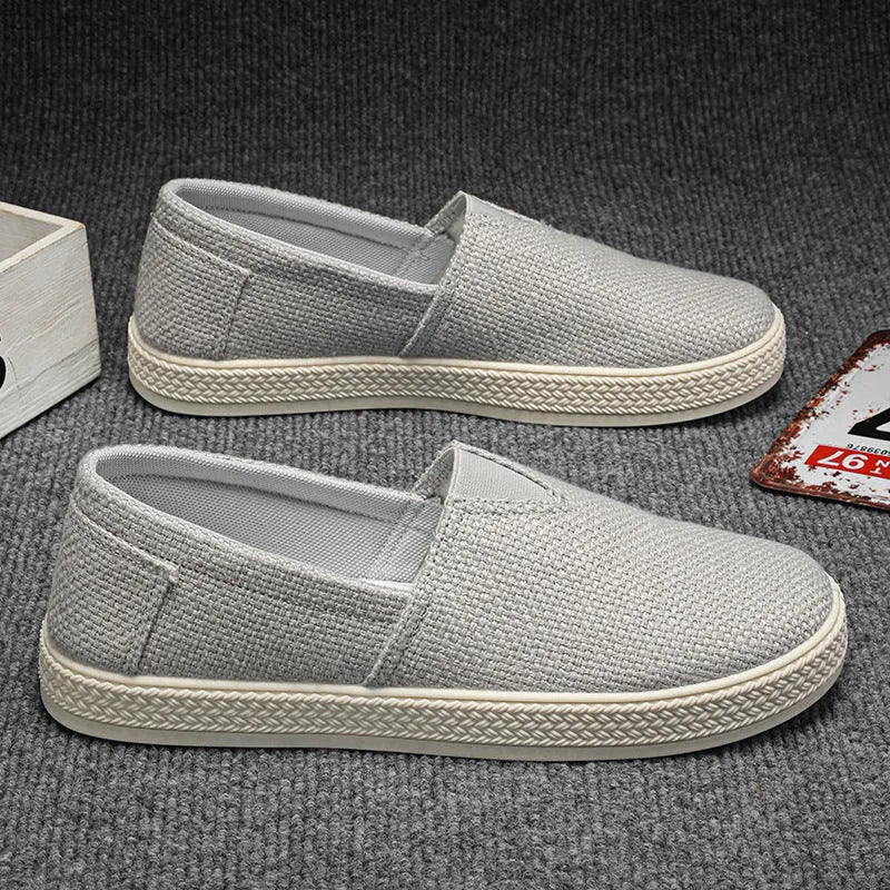 Men's beige canvas slip-on shoes with round toe and PVC sole.