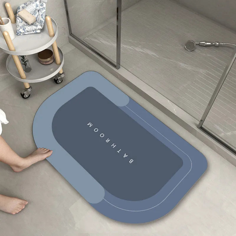 Machine-woven rectangular blue floor mat placed on a bathroom floor.
