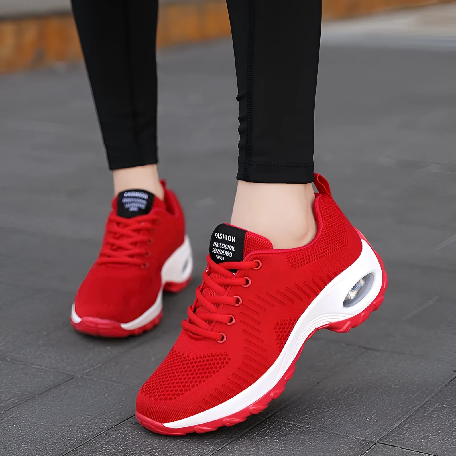 Women's red low-top mesh sneakers with front laces and a round toe, shown on a white background.