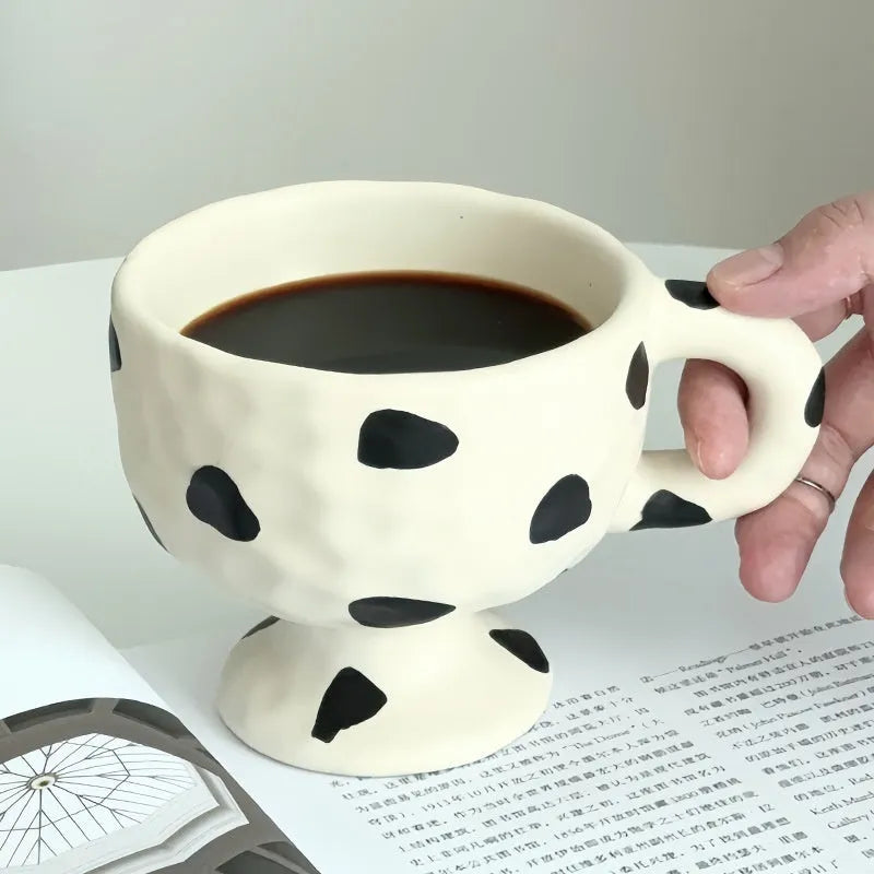 Irregularly shaped hand-pinched ceramic mug in a solid colour, shown on a plain background.