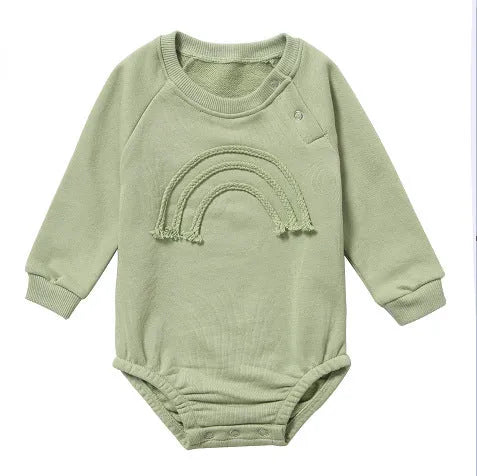 Baby wearing a beige waffle cotton long sleeve romper with rope ties, showing the triangle climbing style.