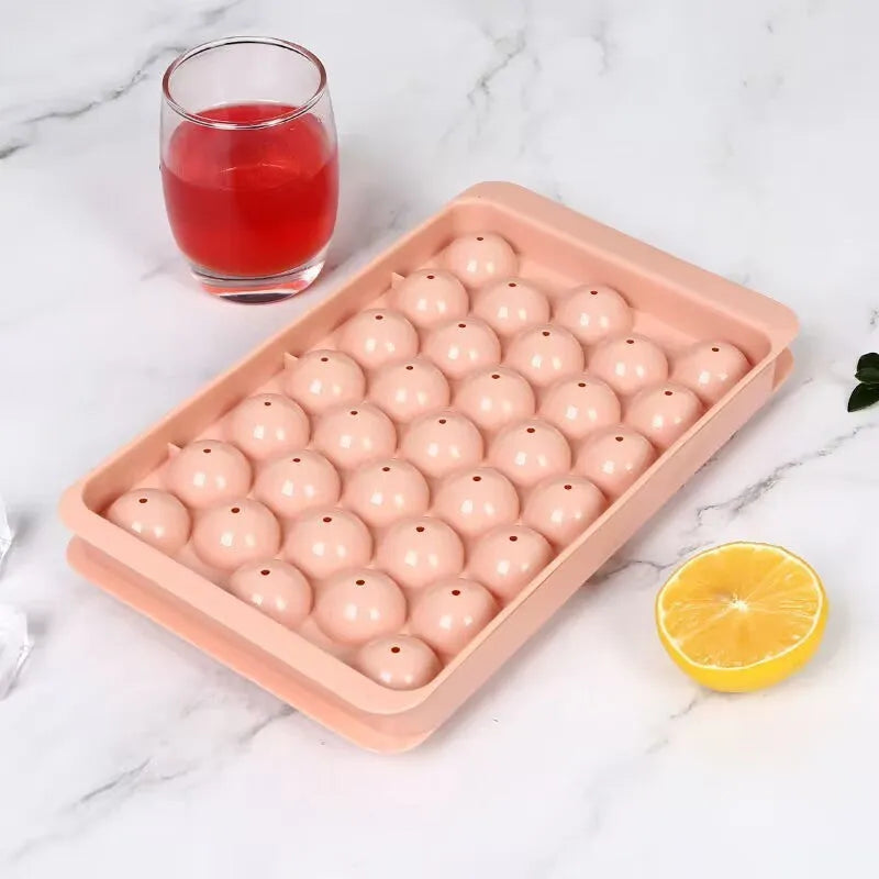 Blue silicone ice tray with lid producing 33 large round ice spheres on a kitchen counter