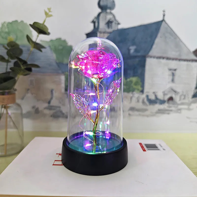 Small decorative night lamp with plastic flowers and a glass-style cover on a black base.