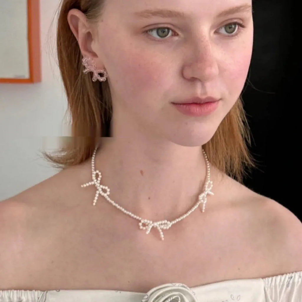 Women's white imitation pearl necklace with sweet bow design and geometric shapes on adjustable chain