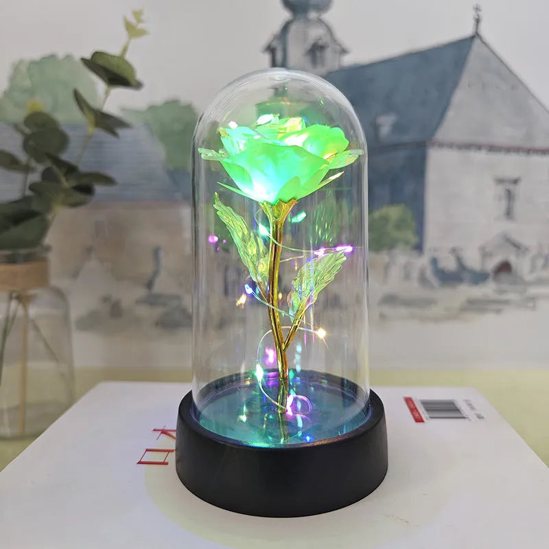 Small decorative night lamp with plastic flowers and a glass-style cover on a black base.