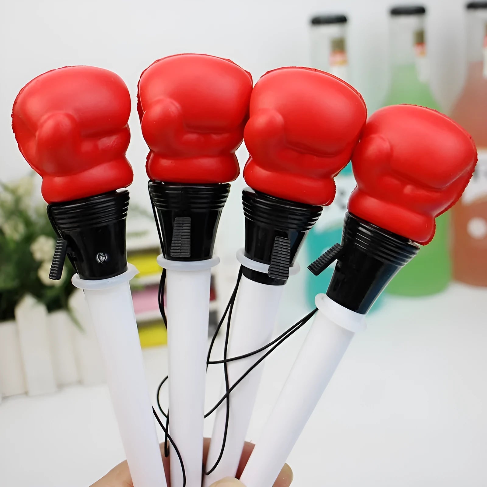 Set of four black creative pressure relief pens with boxing figure press-to-eject mechanism.