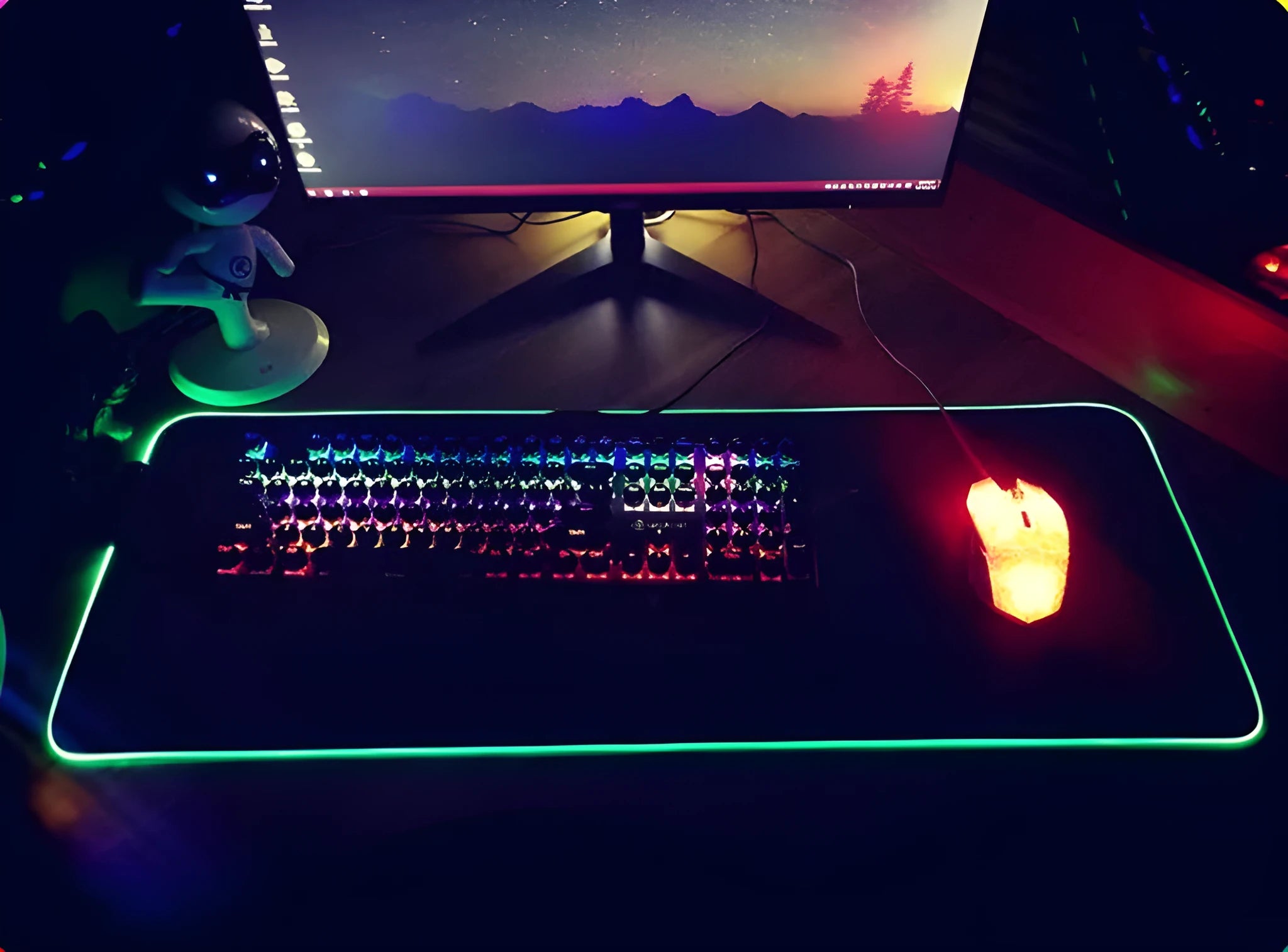 RGB luminous mouse pad with multi-colour LED lighting, fabric surface, and rubber base, shown on a desk with a mouse and keyboard