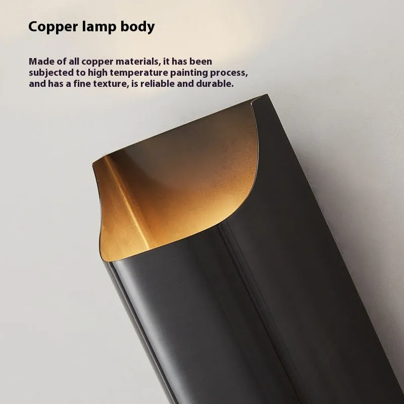 Minimalist copper wall lamp with black gold finish mounted beside bed