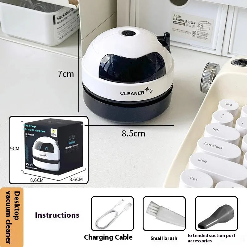 USB-powered handheld desktop vacuum cleaner in blue, placed next to a keyboard with crumbs.