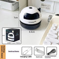 USB-powered handheld desktop vacuum cleaner in blue, placed next to a keyboard with crumbs.
