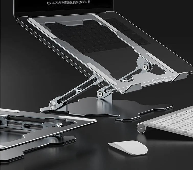 Grey aluminium folding laptop stand shown at an adjustable angle on a wooden desk.