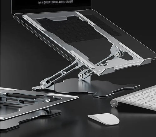 Grey aluminium folding laptop stand shown at an adjustable angle on a wooden desk.