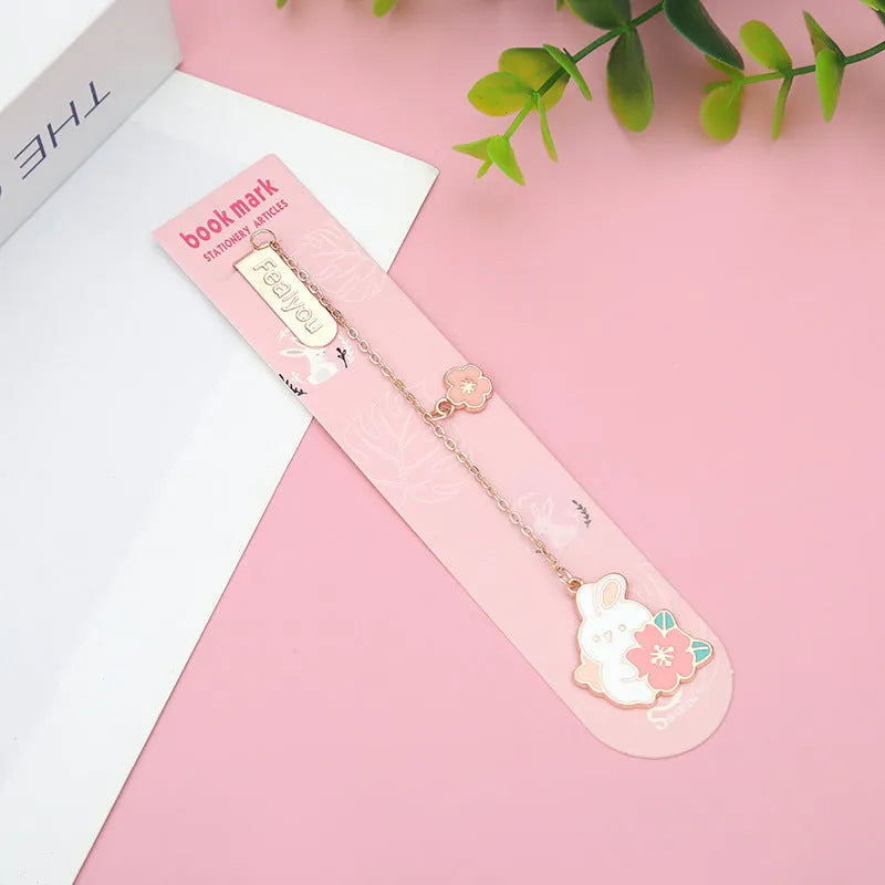 Small metal bookmark pendant with cherry blossom and cartoon cat or rabbit design.