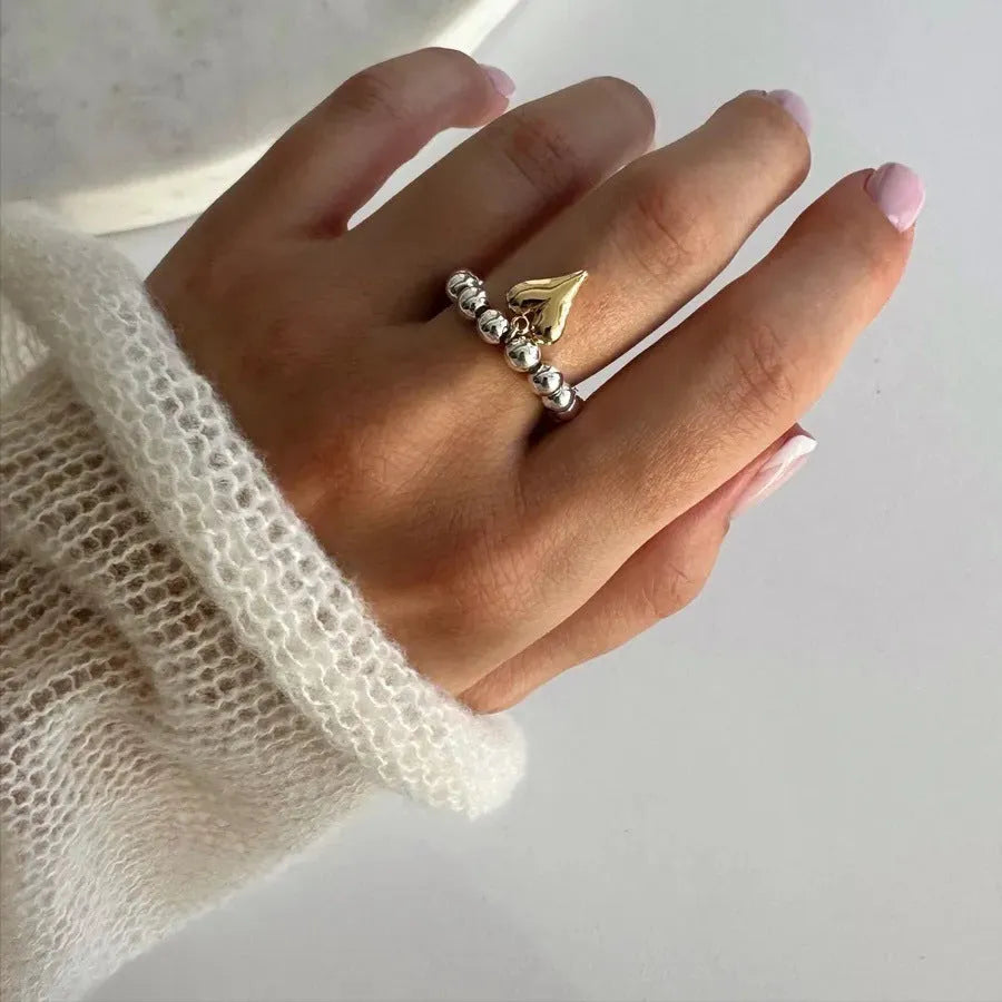 Handmade elastic beaded love ring with geometric heart design in gold and white electroplated finishes