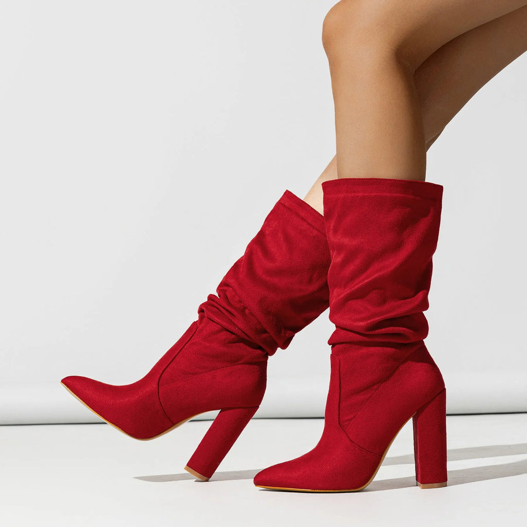 Black suede women's boots with a chunky high heel and pointed toe, shown on a middle calf.