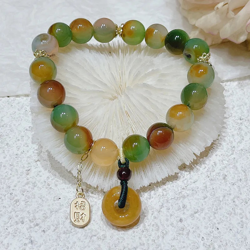 Yellow peacock agate and topaz beaded bracelet with a metal safety chain and peace buckle clasp.
