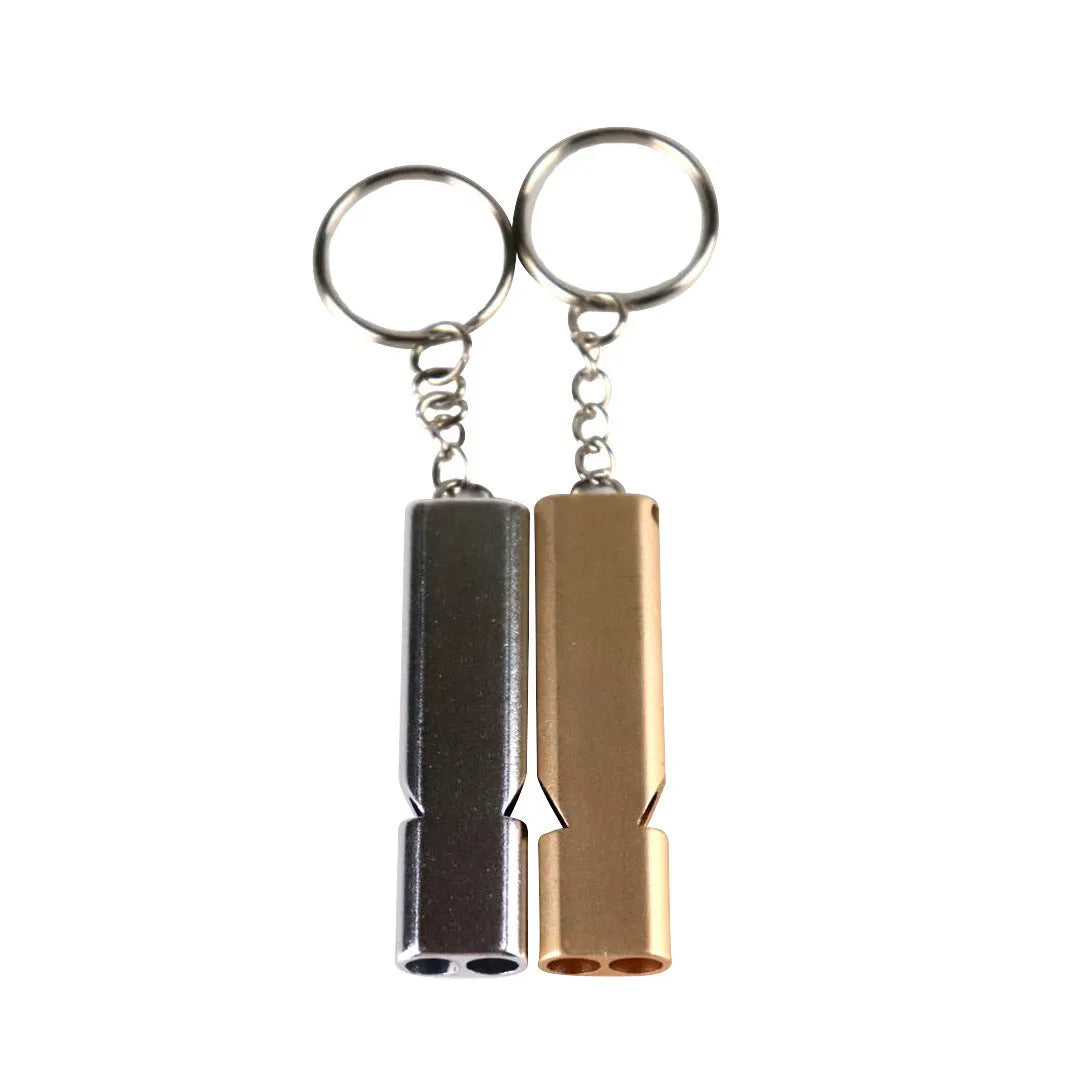 Close-up of a silver aluminium alloy double-hole outdoor survival whistle on a dark background.