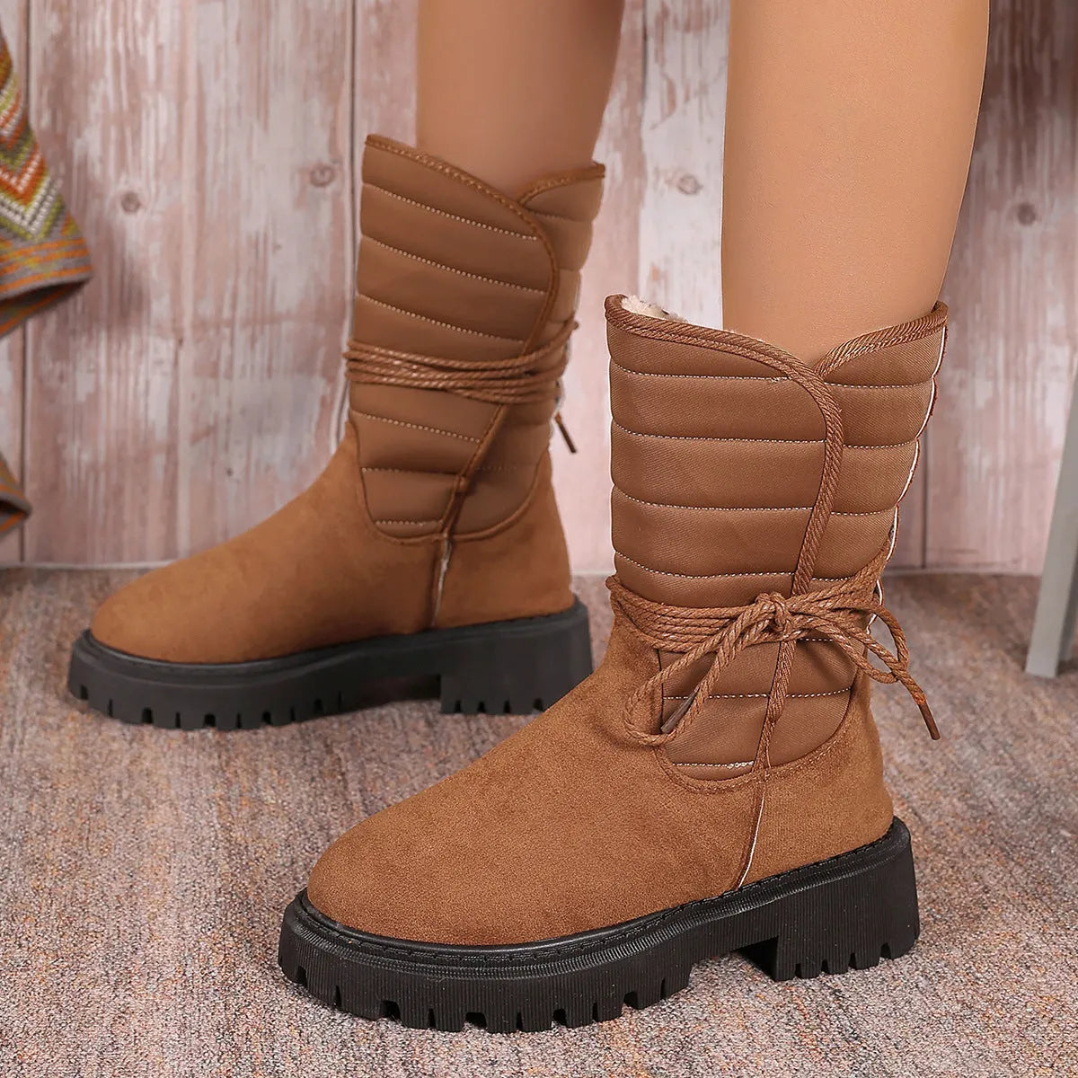 Women's black chunky heel snow boot with suede upper and lace-up design.