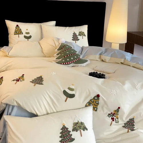 Cream blue cotton duvet cover with embroidered Christmas tree and floral design, laid on a bed with matching pillowcases.