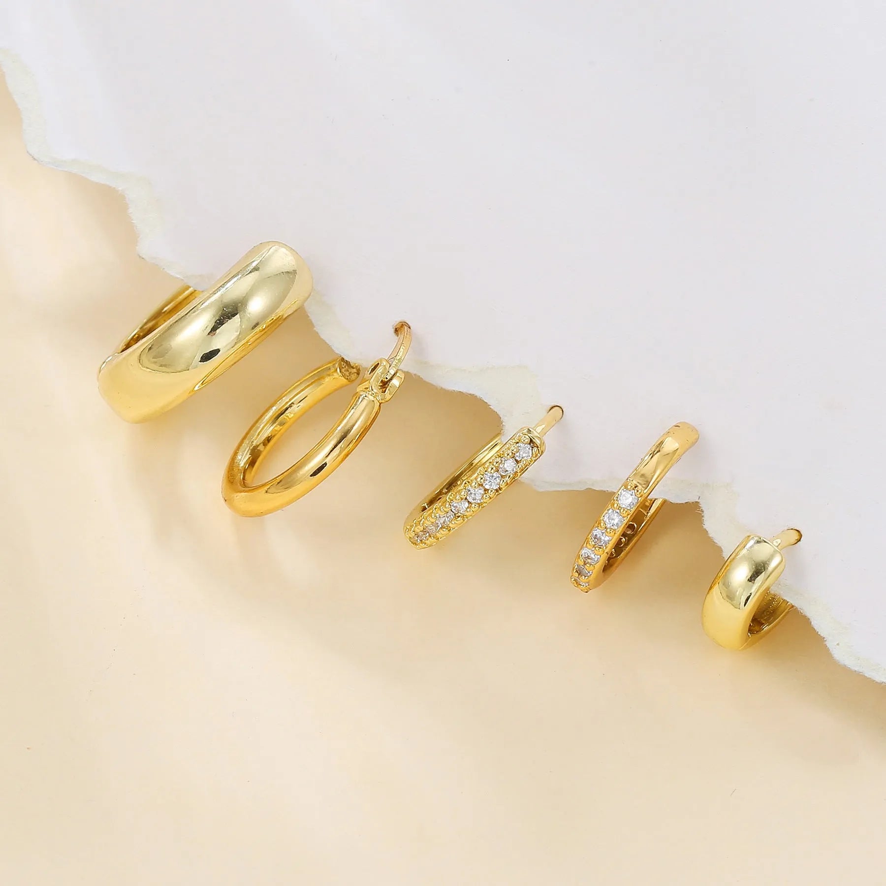 Five round copper earrings with inlaid zircon in gold and white gold colours