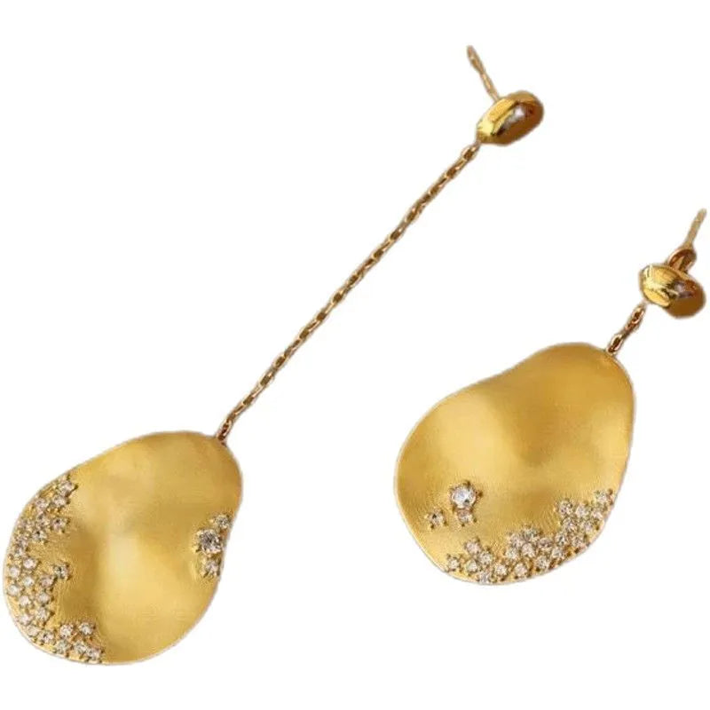Asymmetric floral earrings with zircon stones in gold or silver finish.