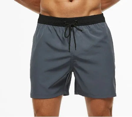 Men's blue stitching waist shorts with a headband pocket and drawstring, laid flat.