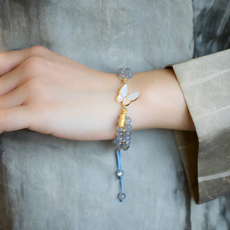Grey moonstone butterfly charm on a handwoven cord bracelet for women.