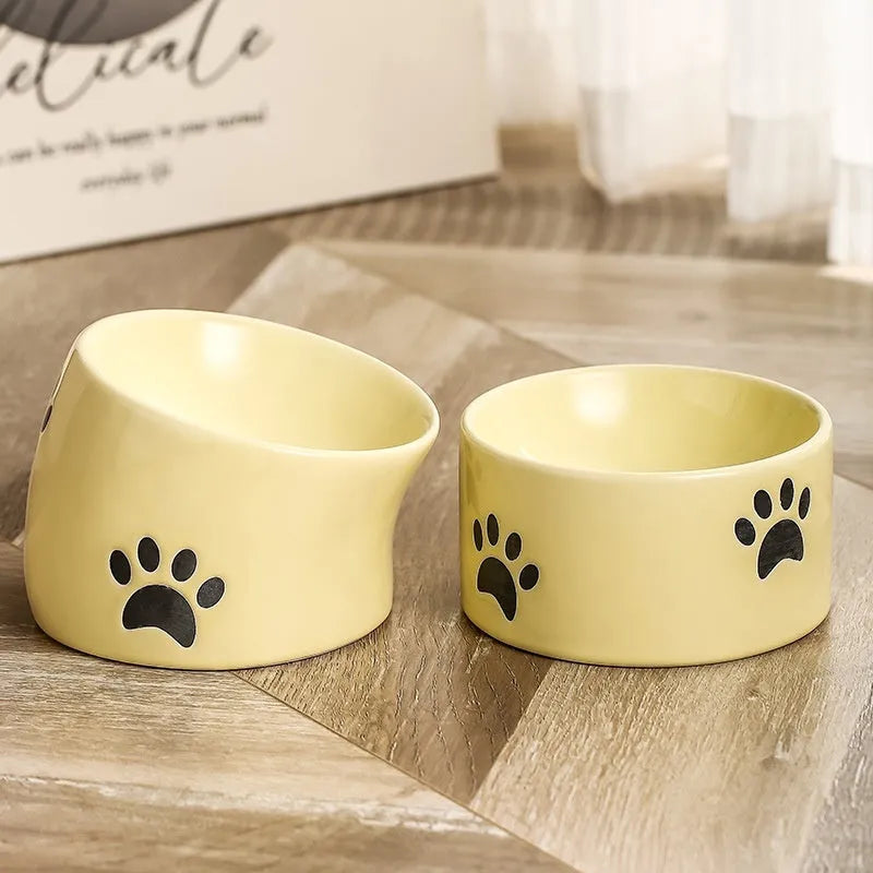 Ceramic cat bowl with cat paw design in black, showing oblique mouth style.
