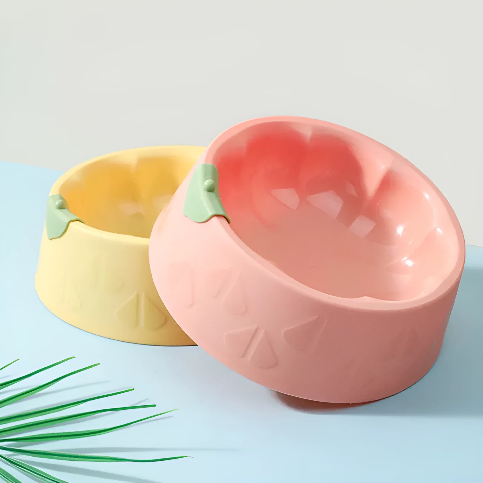 Green flower-shaped plastic double bowl for cat or small dog food and water on a plain surface.
