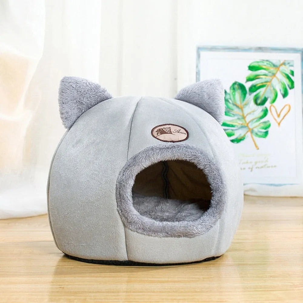 Grey enclosed cat sofa bed with a round entrance hole, showing a soft plush interior and removable cushion.