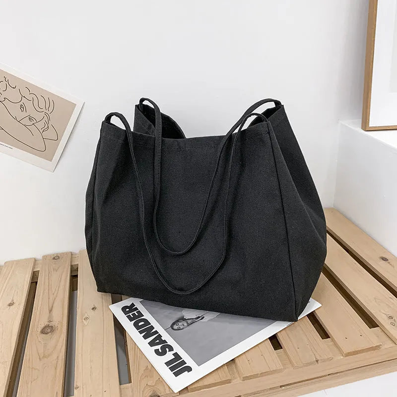 Women's solid colour canvas handbag showing horizontal square shape with double shoulder straps
