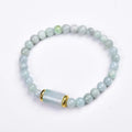 A close-up of a round Myanmar ice jade bead bracelet in emerald colour.