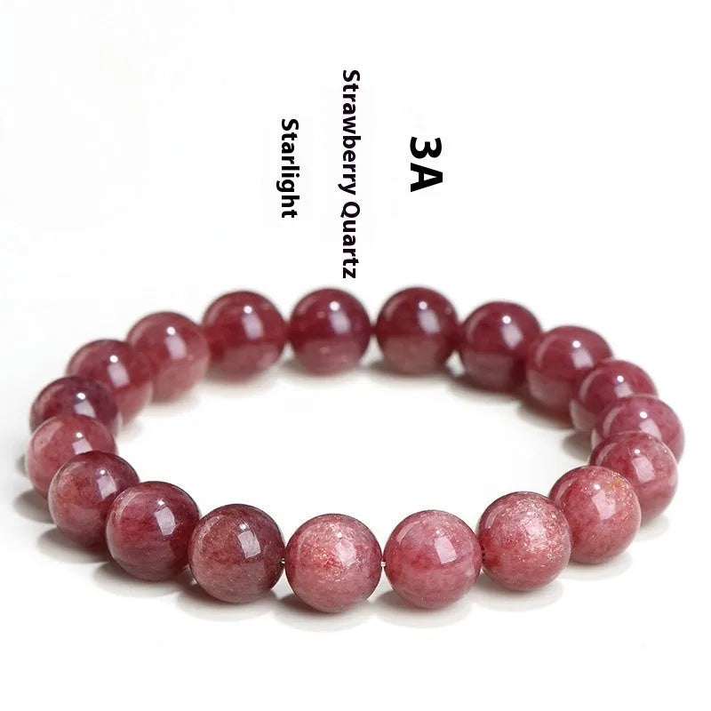 Cherry red strawberry quartz crystal bracelet with geometric beads on a wrist.