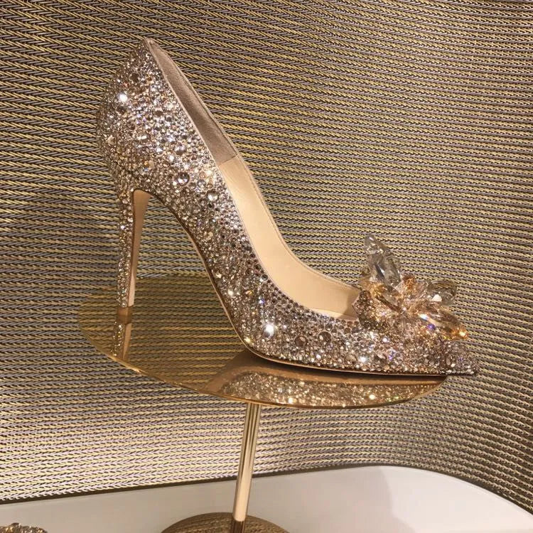 Gold women's pointed toe high heels with rhinestone decoration and a stiletto heel.