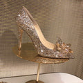Gold women's pointed toe high heels with rhinestone decoration and a stiletto heel.
