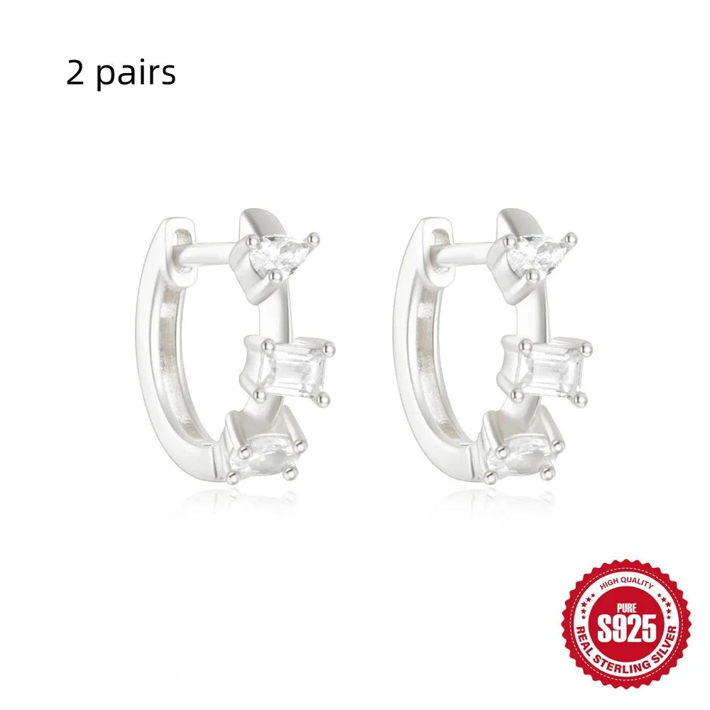 A pair of small round geometric stud earrings in sterling silver with a gold electroplated finish.