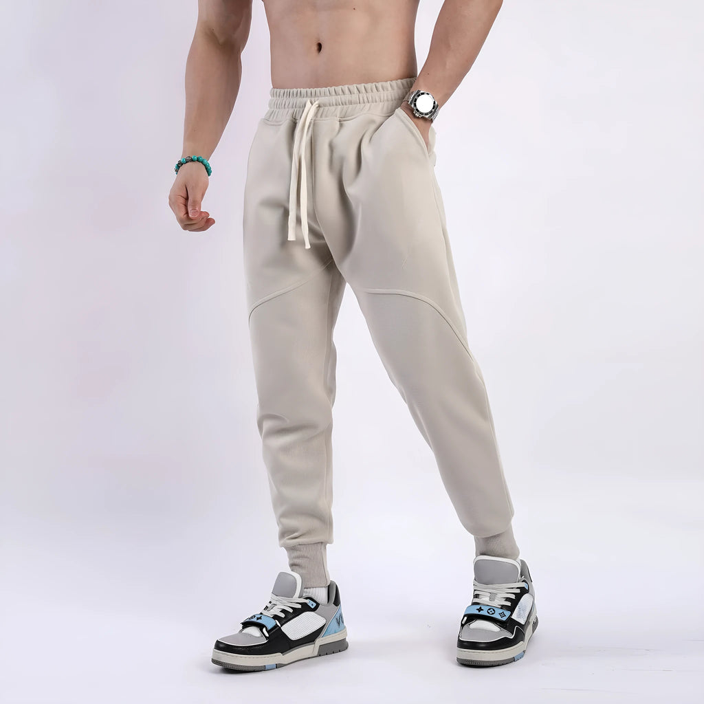 Man wearing grey ankle-tie drawstring sweatpants for casual leisure.