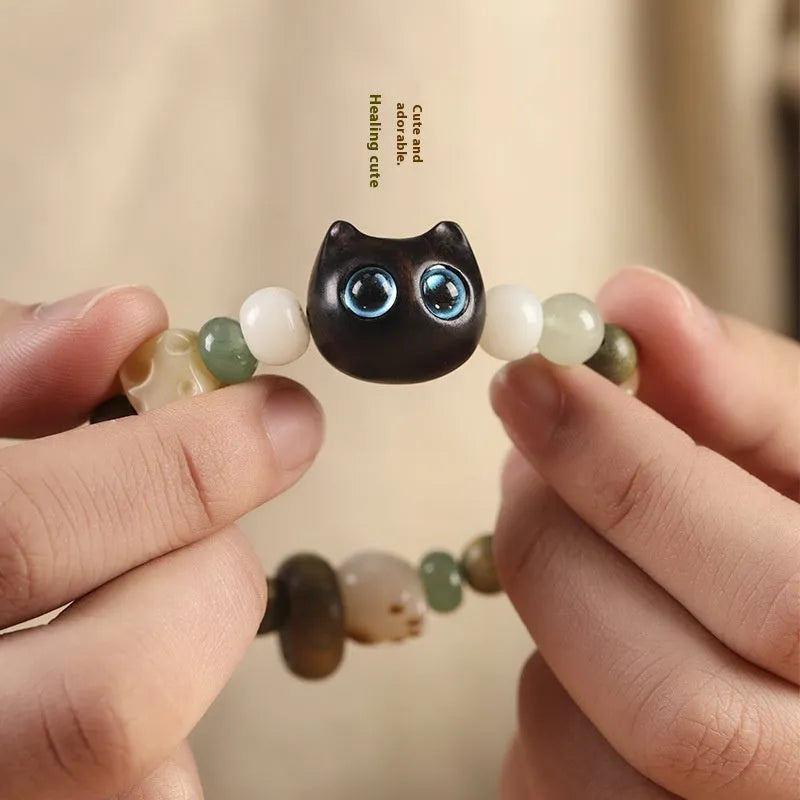 Hand-woven adjustable bracelet with bodhi seeds, jade beads, and a cartoon cat's paw guajacwood charm