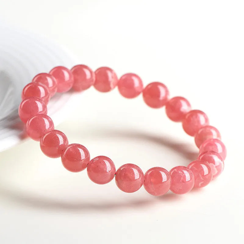 Women's geometric red rhodochrosite crystal bracelet with a longevity lock on a white background.