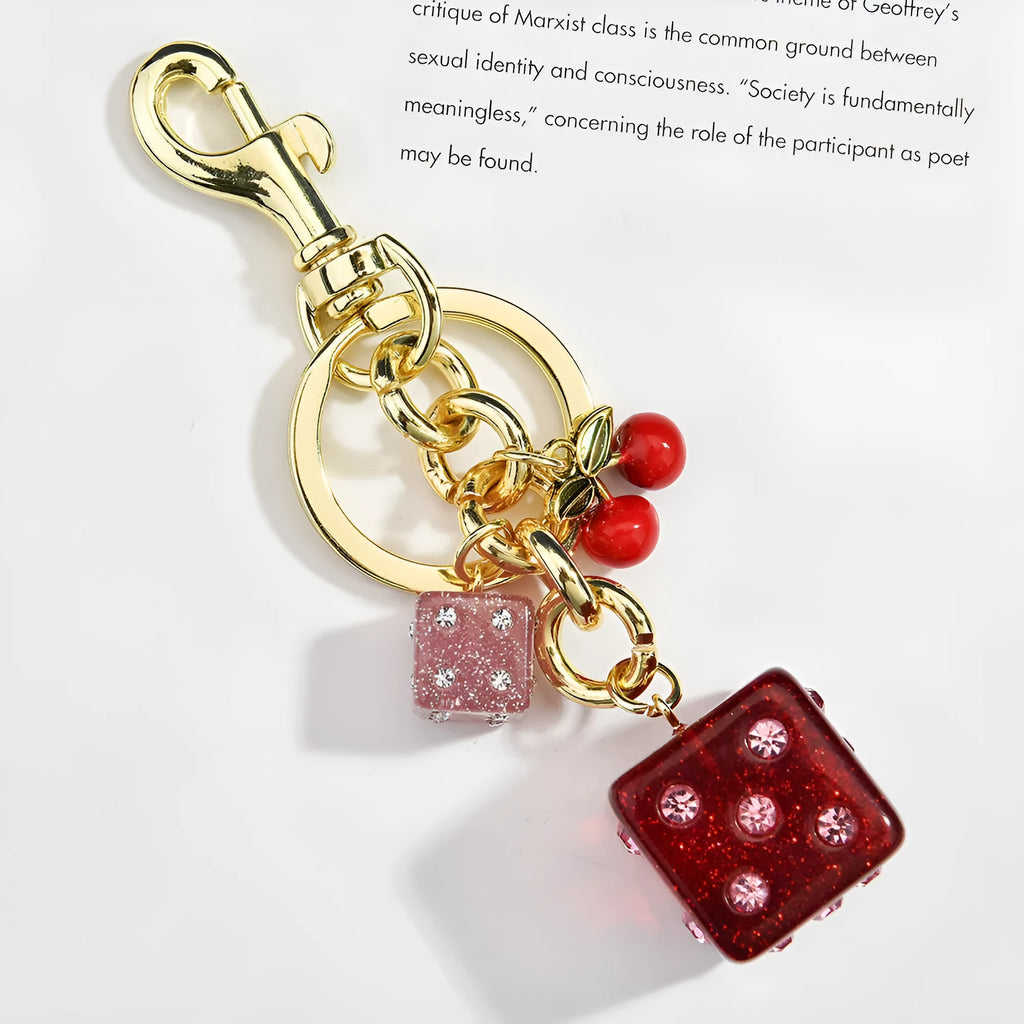 Square cherry red and silver two-tone dice keychain pendant with metal keyring on a grey background