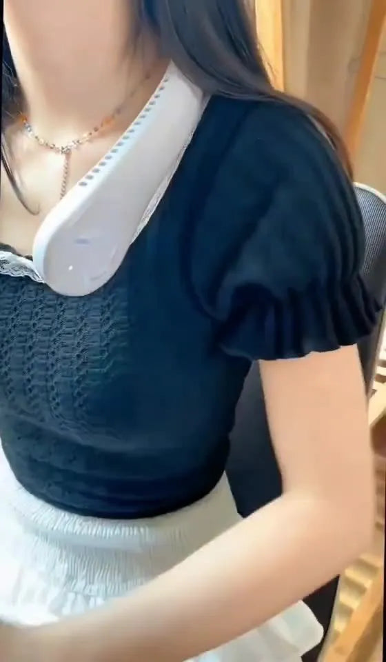 Blue bladeless neck fan hanging around a person's neck, showing the air outlet and USB charging port.