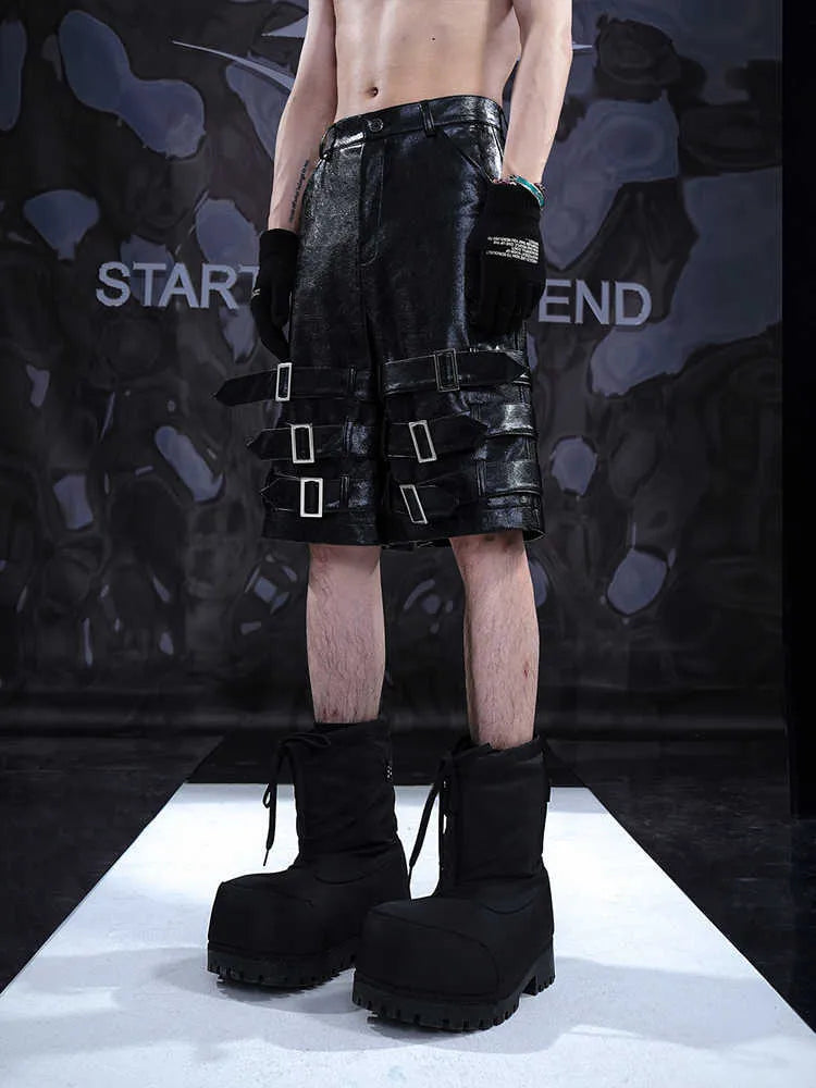 Man wearing black cropped PU leather shorts with a distinctive ring detail on the leg.