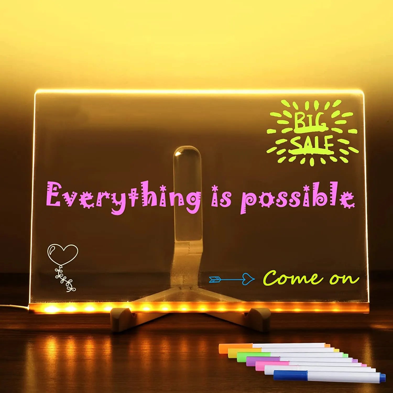 Acrylic DIY LED message board on a bracket, glowing softly with handwritten notes, alongside white and colourful pens.