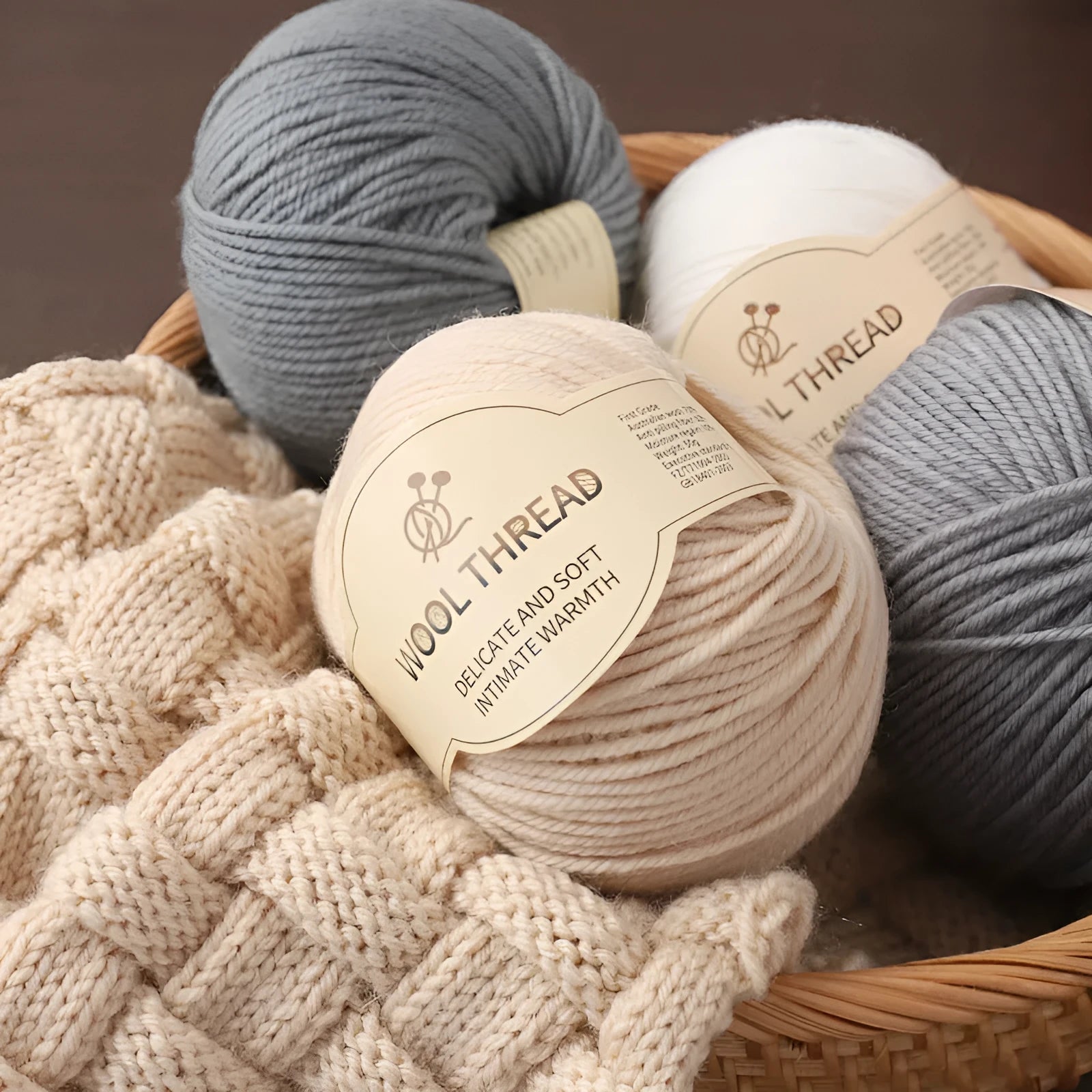 One roll of beige domestic wool hand-knitting yarn for size 10 needles next to knitting needles.