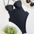 Solid black one-piece swimsuit for women on a hanger