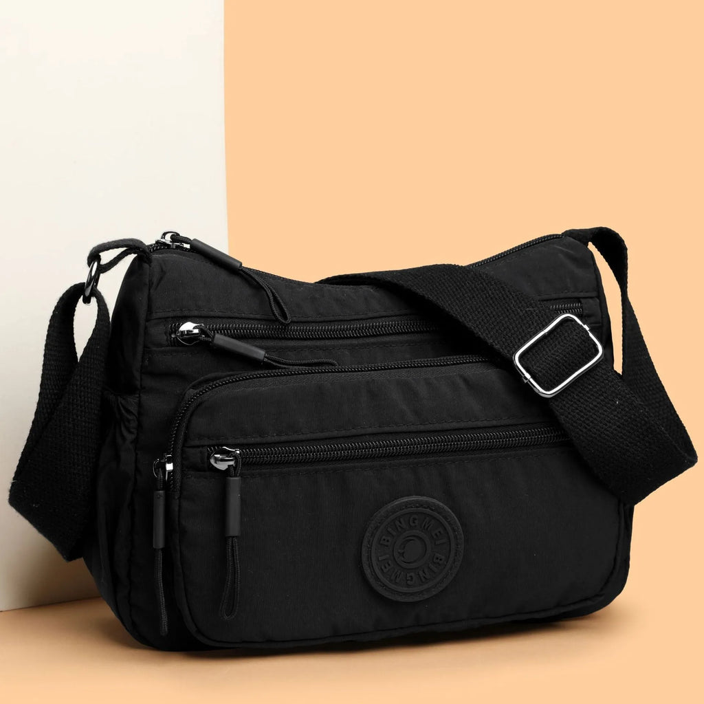Soft water-repellent nylon crossbody bag showing three-dimensional pocket and adjustable shoulder strap