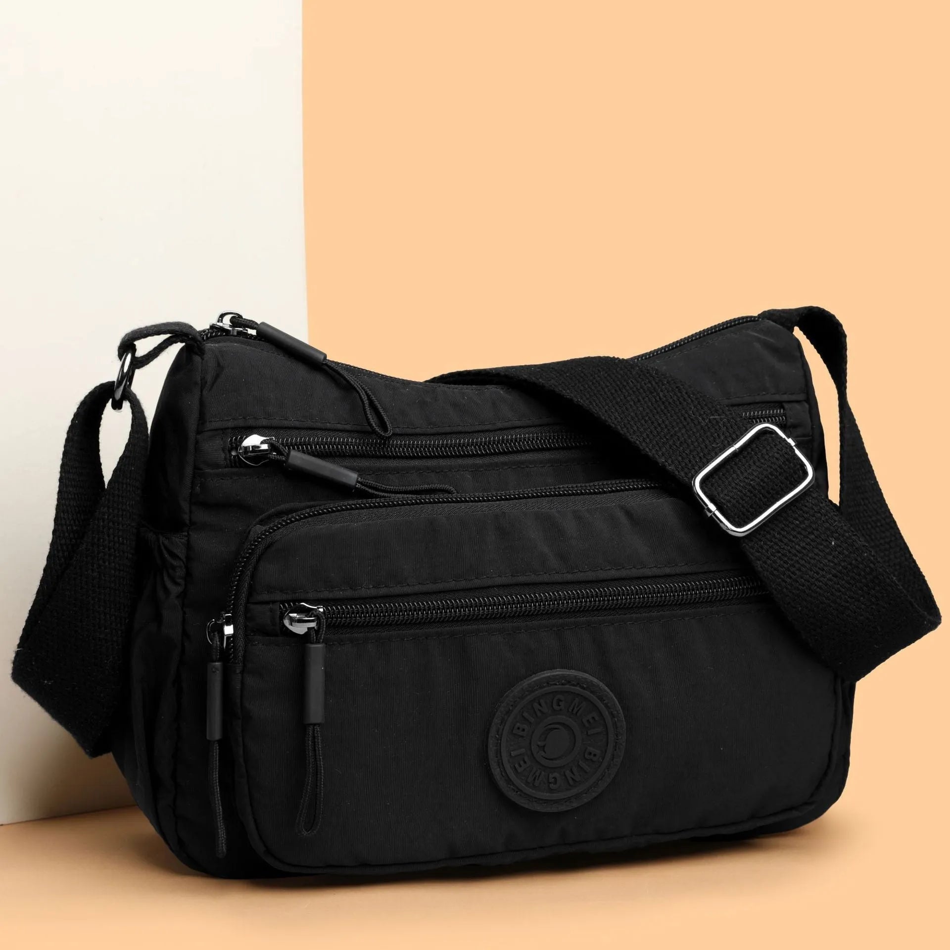 Soft water-repellent nylon crossbody bag showing three-dimensional pocket and adjustable shoulder strap