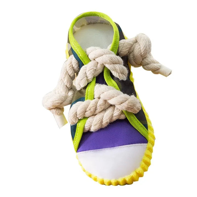 Grey and white dog toy slipper with black laces, blue sole, and a bell on the side