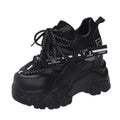 Women's white mesh platform sports shoe with cross strap and rubber sole on a neutral background.